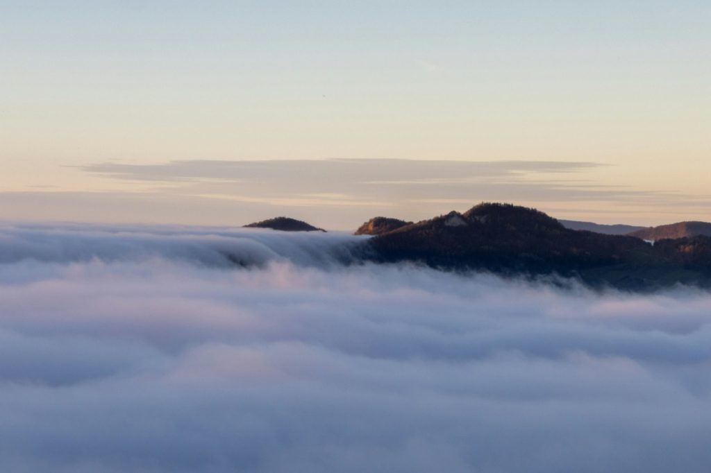 A mountain top peeking through a white fluffy cloud, Solothurn, Wisen municipality of Switzerland